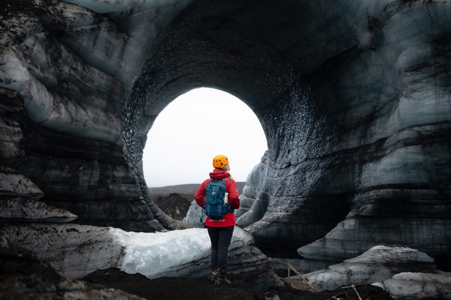 exploradora cruzando arco cueva hielo glaciar islandia