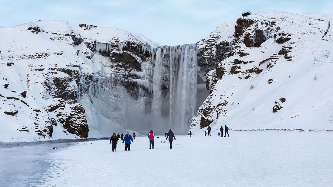 cascada nevada turistas invierno islandia